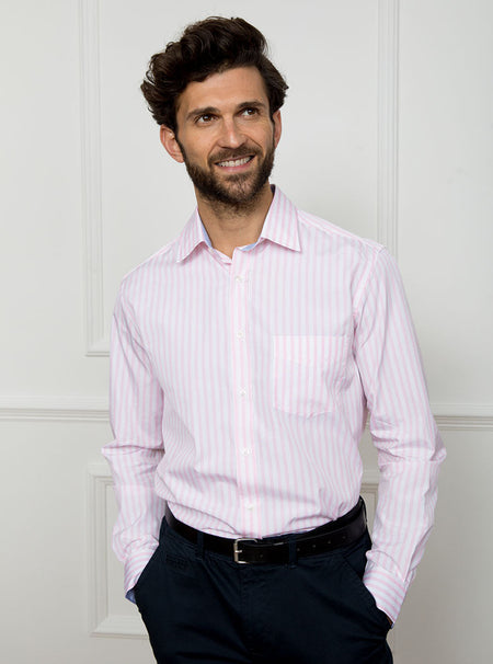 Man wearing long sleeved shirt with pale pink and white stripe made with 100% cotton from Thomas Mason.